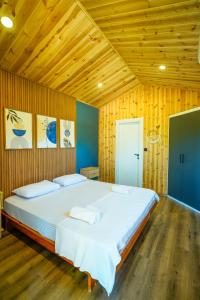 a large bed in a room with wooden walls at Marimare Beach & Bungalow in Marmaris +34 photos