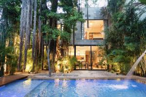 a house surrounded by trees with a swimming pool at Hum Living Luxury Villas in Tulum +9 photos