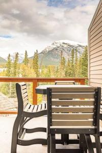 a table and chairs on a balcony with a view of a mountain at Mountain Luxe in Canmore
