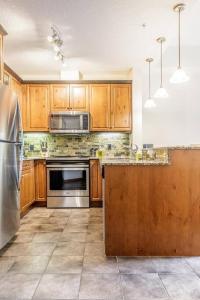 a kitchen with wooden cabinets and stainless steel appliances at Mountain Luxe in Canmore
