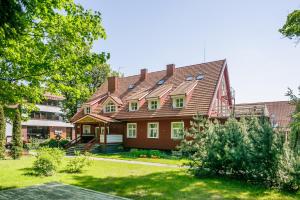 una casa grande con techo de gambrel en Raze, en Palanga