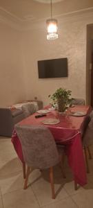 una mesa de comedor con un mantel rojo. en Appartement hory, en Martil