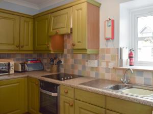 a kitchen with green cabinets and a sink at The Barn in Fintry