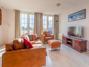 a living room with a couch and a flat screen tv at Schippershuis Stavoren in Stavoren