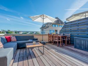 a living room with a couch and an umbrella on a deck at Schippershuis Stavoren in Stavoren