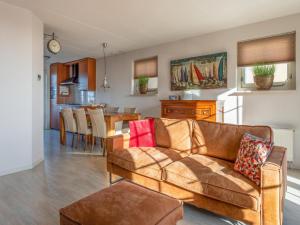 a living room and kitchen with a couch and a table at Schippershuis Stavoren in Stavoren
