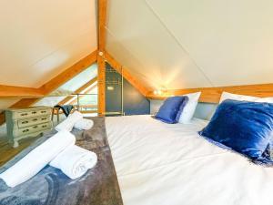 a bedroom with a bed with blue pillows at Onirico in Alphen