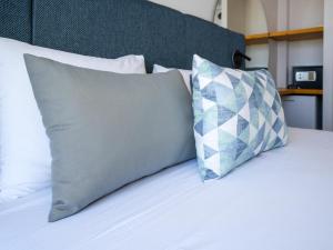 a bed with two pillows on top of it at Seaside Marmari in Marmari