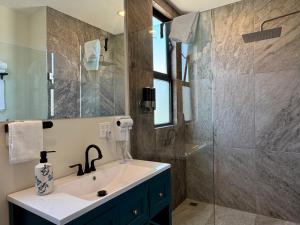 a bathroom with a sink and a shower at Suites Lassa in Ensenada