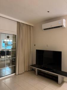 a living room with a large flat screen tv at dana beach resort in Half Moon Bay