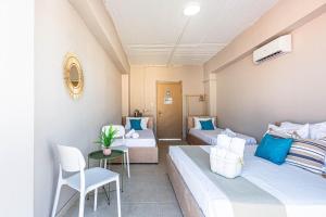 a hotel room with two beds and a table and chairs at Himara City 52 - Central & Beach Access in Himare