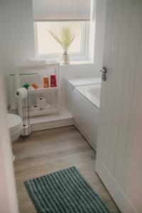 a bathroom with a tub and a toilet and a window at Modern Stay - Walk to Everything 1 in Ipswich