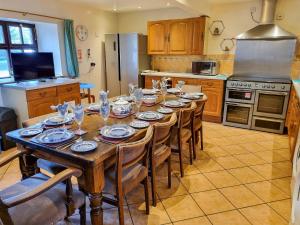 a kitchen with a wooden table with plates and glasses on it at The Barn - B6206A in Onecote