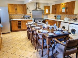 a kitchen with a wooden table with chairs and a kitchen with a refrigerator at The Barn - B6206A in Onecote
