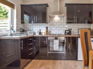 una cucina con lavello e fornello forno superiore di Rowan Cottage a Walton West