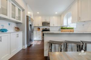a kitchen with white cabinets and a counter with bar stools at Vitamin Sea 0.6 miles to beach, monthly disc in Destin