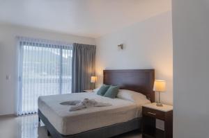 フォルトゥナにあるHotel Arenal by Reginaのタオルが敷かれたベッドのある寝室