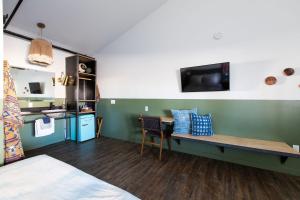 a room with a bed and a desk and a kitchen at Mellow Moon Lodge in Del Norte