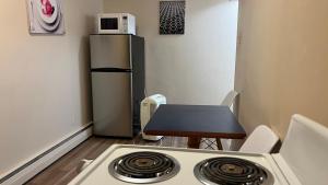 Una pequeña cocina con estufa y refrigerador. en Admiral's Quay Motel & Suites, en Saint John