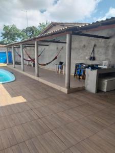 Una gran terraza con una mesa y una piscina. en Casa de Praia, en Belém