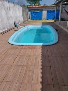 Una piscina en una terraza de madera con una bañera azul. en Casa de Praia, en Belém