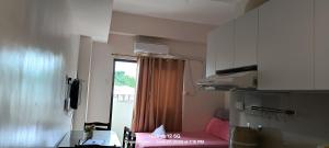 a small room with a pink couch and a window at Thyme residences condominium, Unit 208 in Cebu