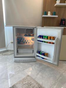 a small refrigerator with its door open in a kitchen at Pyramids Top Roof in Ghaţāţī