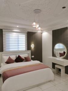 a bedroom with a large bed and a mirror at شقق النبلاء in Al Madinah