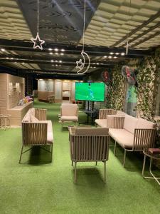 a living room with chairs and a tv in it at Pyramids Top Roof in Ghaţāţī +10 photos