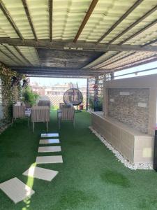 a patio with a fireplace and chairs and a table at Pyramids Top Roof in Ghaţāţī