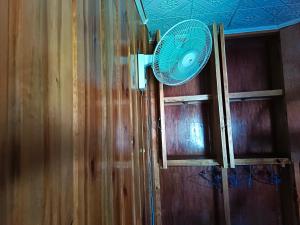 a fan on a wall next to a wooden wall at Joysean Transient House in Sagada