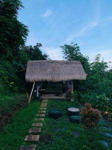 a grass hut with two tires in the grass at Laa Cabana Lombok Glamping in Sapit