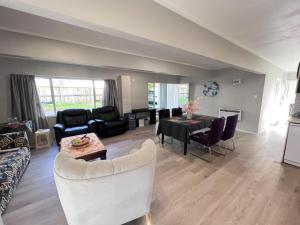 a living room with a couch and a table at Wast area 3 bedroom home at Massey in Auckland