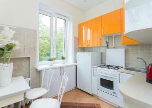 una cucina con elettrodomestici bianchi e armadietti arancioni di Daily tovar a Tashkent