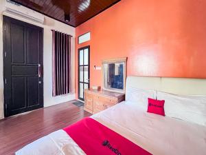 a bedroom with a large bed and a mirror at RedDoorz Syariah near Suncity Waterpark Sidoarjo in Sidoarjo