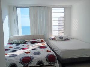 a bedroom with two beds and a window with the ocean at Penthouse frente al mar in Tonsupa