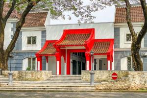 a house with a red structure in front of it at RedDoorz Yasmine Syariah near Taman Dayu in Jetak