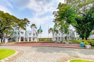 a large white building with trees in front of it at RedDoorz Yasmine Syariah near Taman Dayu in Jetak