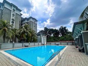 une grande piscine bleue avec des palmiers et des bâtiments dans l'établissement Cozy Loft Bed Mini Studio Golf View, à Gua Sai