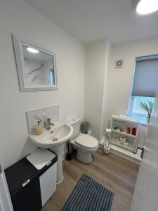 a white bathroom with a sink and a toilet at Modern Stay - Walk to Everything 4 in Ipswich