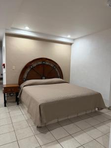 a bedroom with a large bed with a wooden headboard at Casa Olas in Puerto Vallarta
