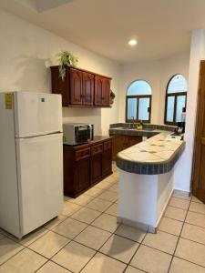 a kitchen with a white refrigerator and wooden cabinets at Casa Olas in Puerto Vallarta +31 photos