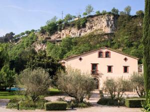 una casa di fronte a una montagna alberata di Farmhouse in Anoia near Montserrat Monastery a Capellades