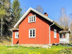 a red house with white windows in a field at 4 star holiday home in ISTORP in Istorp