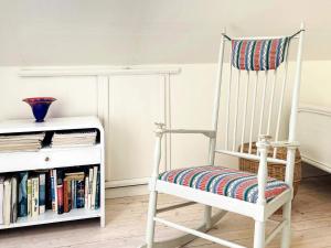 a white rocking chair sitting next to a book shelf at 4 star holiday home in ISTORP in Istorp