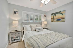 a white bedroom with a bed and a window at Barefoot In Lantana in Lantana +15 photos