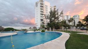 een groot zwembad voor een gebouw bij Beach Patio Paradise in Cancun