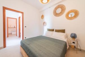 a bedroom with a bed and two mirrors on the wall at A Me Casa - Taormina in Taormina