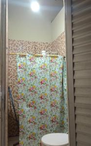a shower curtain in a bathroom with a toilet at Hospedaria lençóis em santo amaro MA in Santo Amaro
