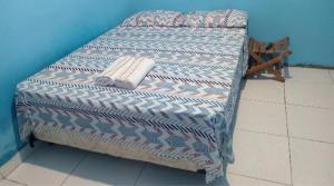 a bed with a quilt on it in a room at Hospedaria lençóis em santo amaro MA in Santo Amaro